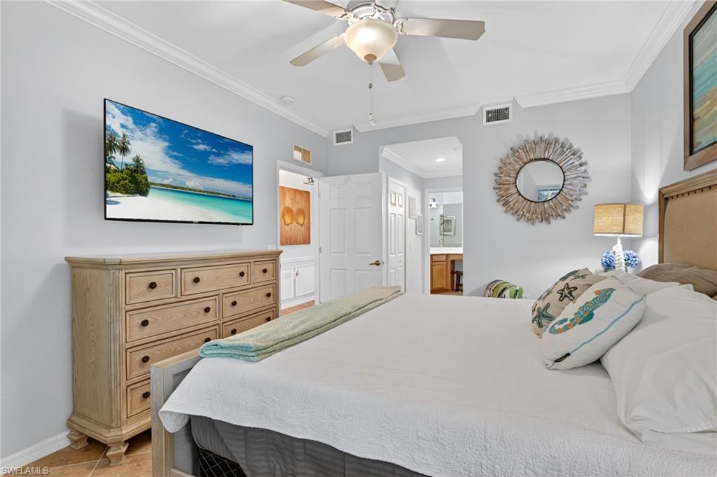 9513 Avellino Way, Unit 2014 Naples, FL 34113 - Photo 14 of 41 a bedroom with a bed and a chandelier