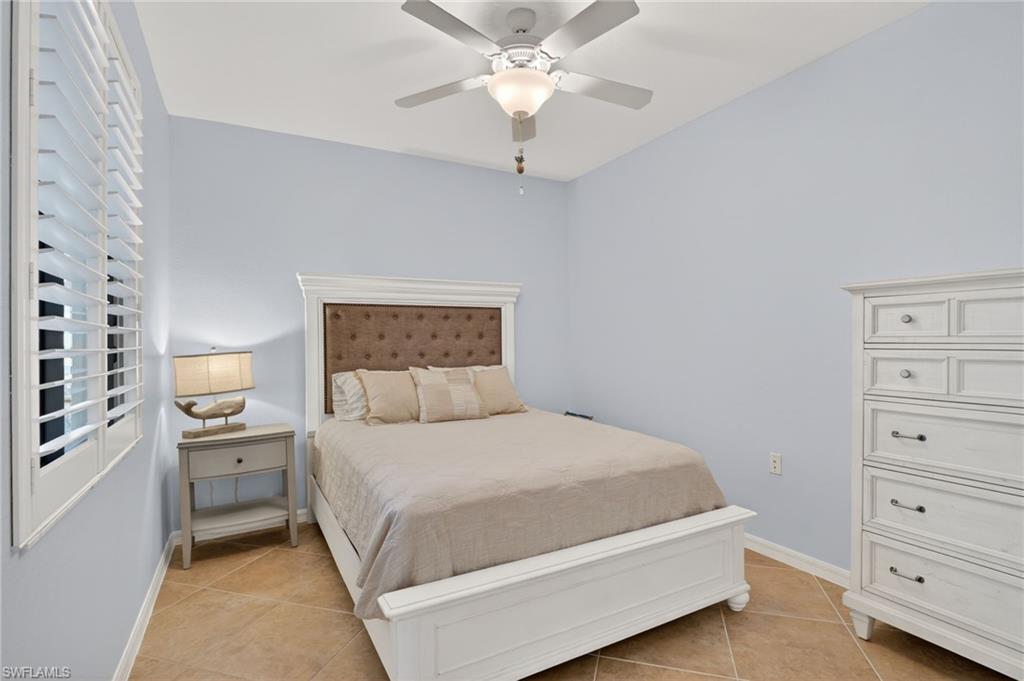 9513 Avellino Way, Unit 2014 Naples, FL 34113 - Photo 17 of 41 a bedroom with a bed and a chandelier