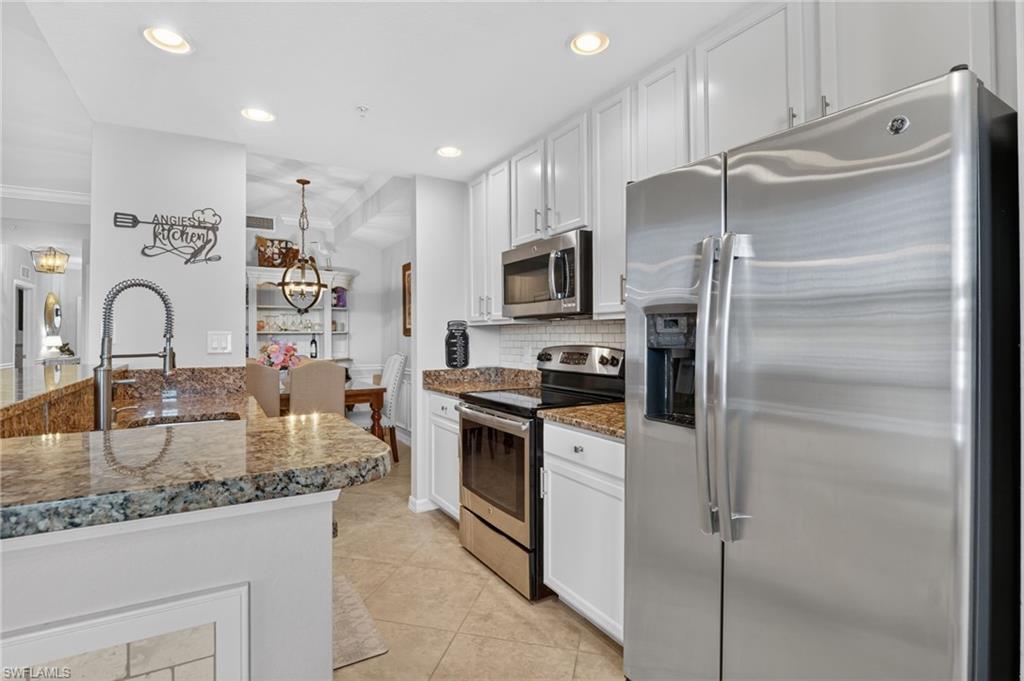 9513 Avellino Way, Unit 2014 Naples, FL 34113 - Photo 24 of 41 a kitchen with granite countertop a refrigerator and a sink
