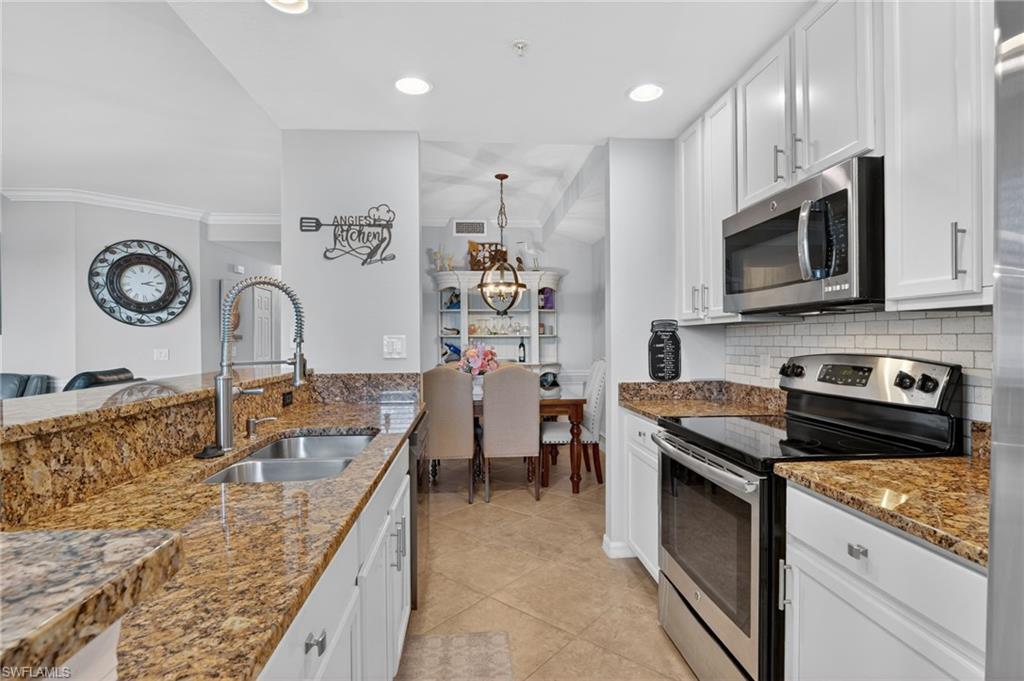 9513 Avellino Way, Unit 2014 Naples, FL 34113 - Photo 27 of 41 a kitchen with granite countertop cabinets a sink and a stove