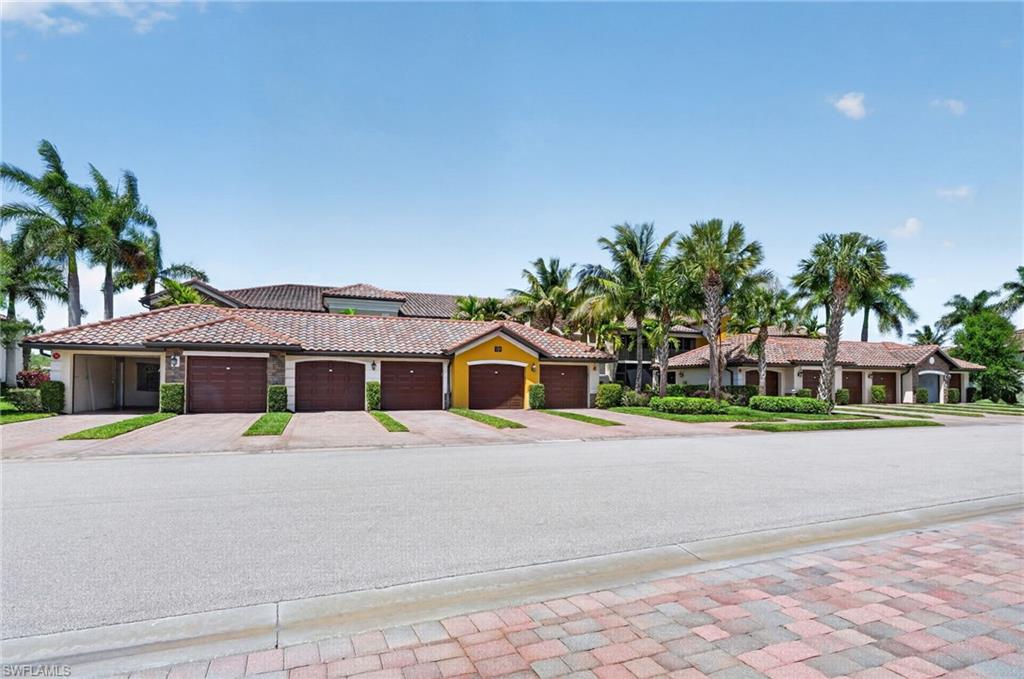 9513 Avellino Way, Unit 2014 Naples, FL 34113 - Photo 33 of 41 a front view of a house with a yard and potted plants