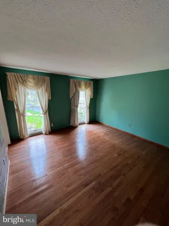 an empty room with a fireplace and wooden floor