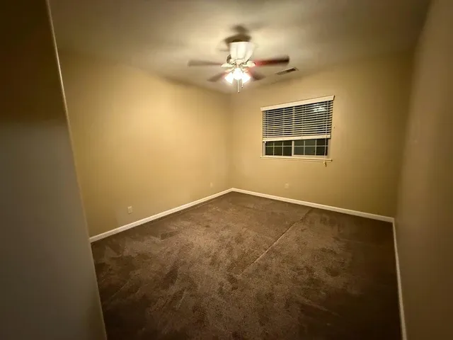 an empty room with closet and a chandelier fan