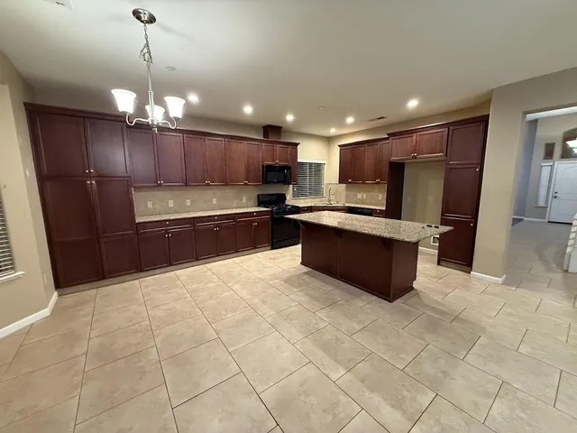 a large kitchen with stainless steel appliances kitchen island granite countertop a large counter top and oven