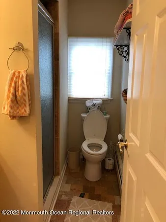 a bathroom with a toilet and a window