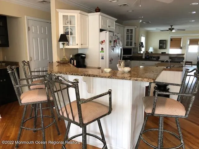 a kitchen with stainless steel appliances kitchen island granite countertop a table chairs and a refrigerator