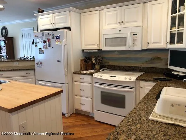 a kitchen with white cabinets and white appliances