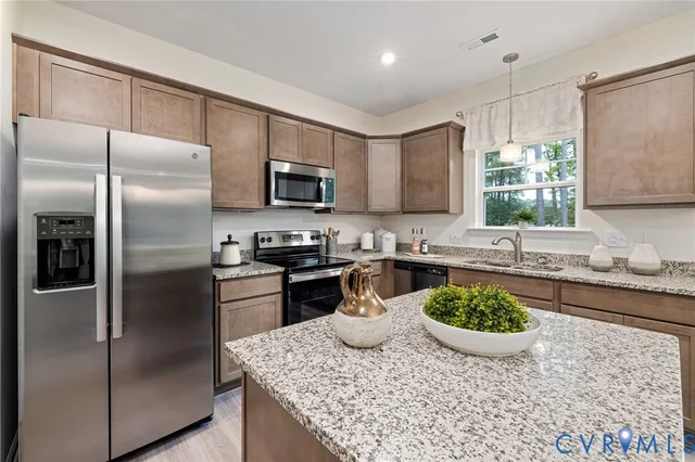a kitchen with a stove a sink and a refrigerator