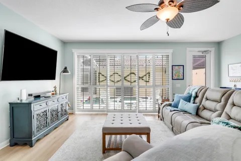 a living room with furniture a flat screen tv and a large window