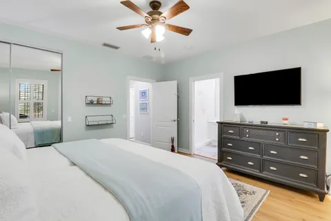 a bedroom with a bed a flat screen tv and a chandelier