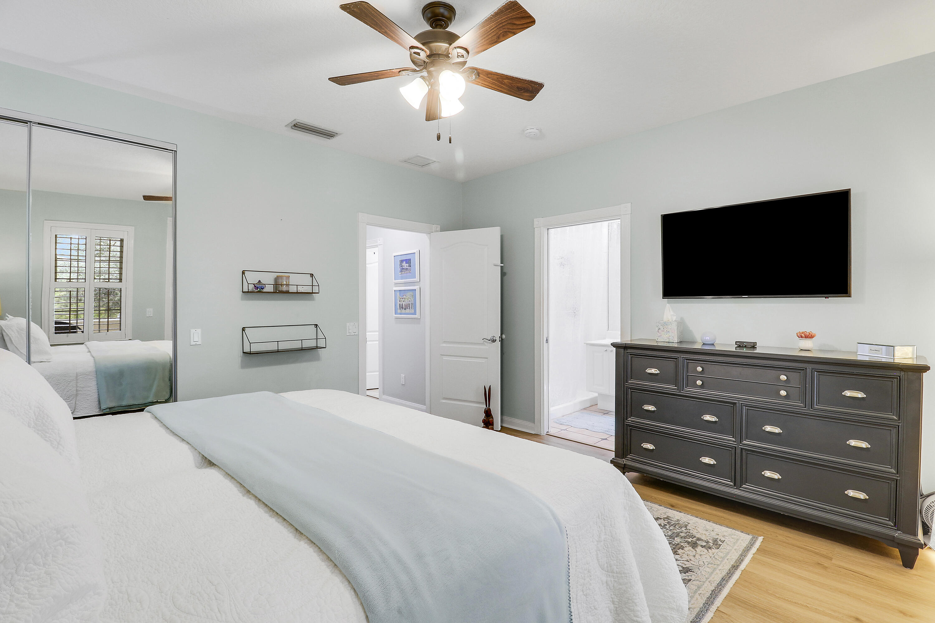 151 Rivinia Drive Jupiter, FL 33458 - Photo 21 of 40 a bedroom with a bed a flat screen tv and a chandelier