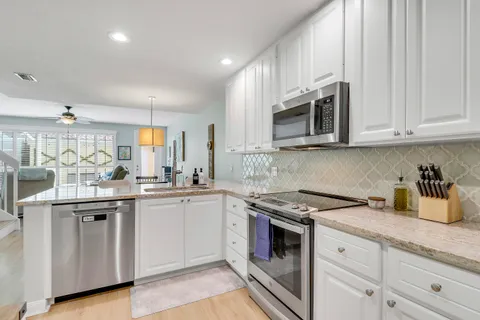 a kitchen with granite countertop cabinets stainless steel appliances and a sink