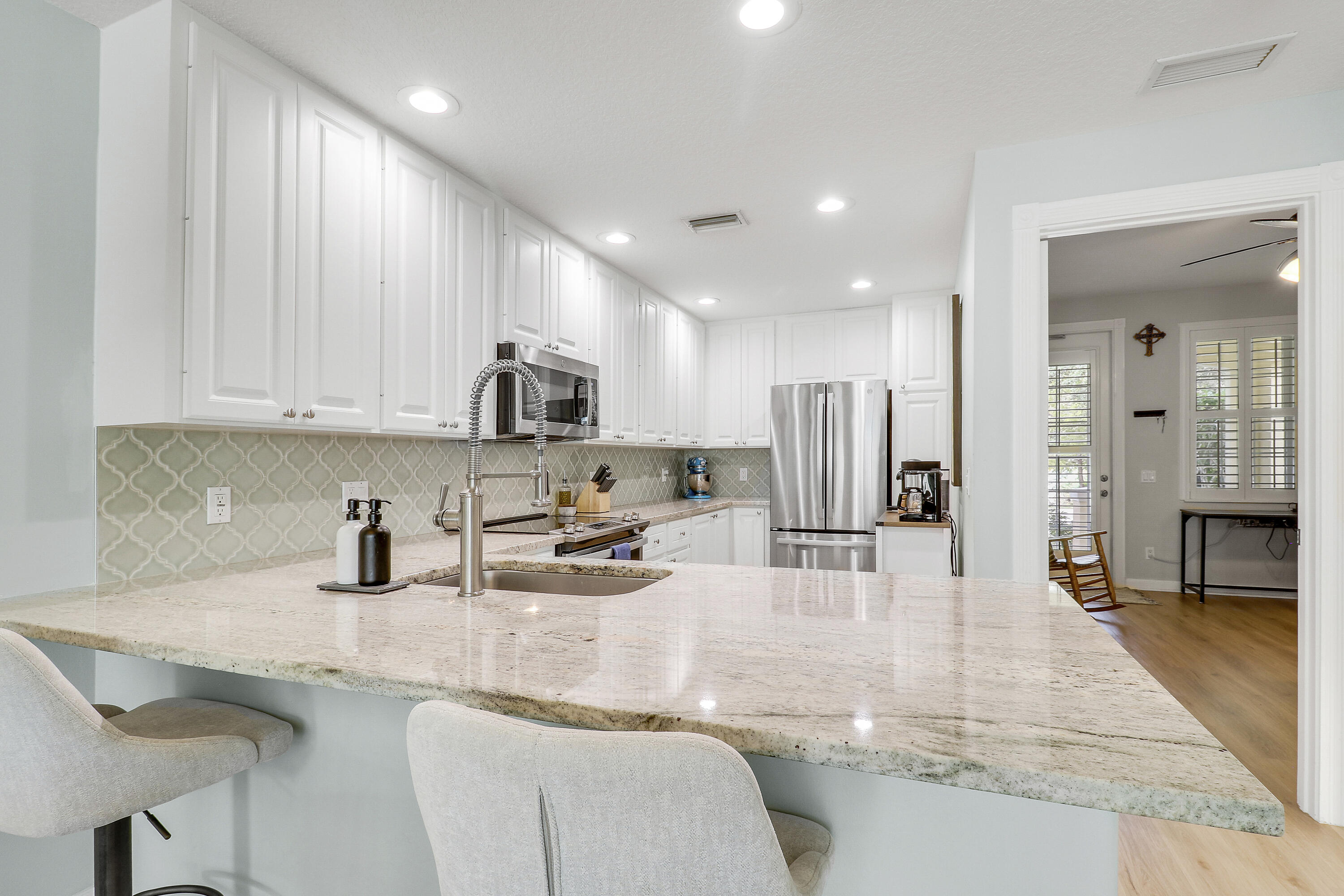 151 Rivinia Drive Jupiter, FL 33458 - Photo 4 of 40 a kitchen with stainless steel appliances granite countertop a sink and cabinets