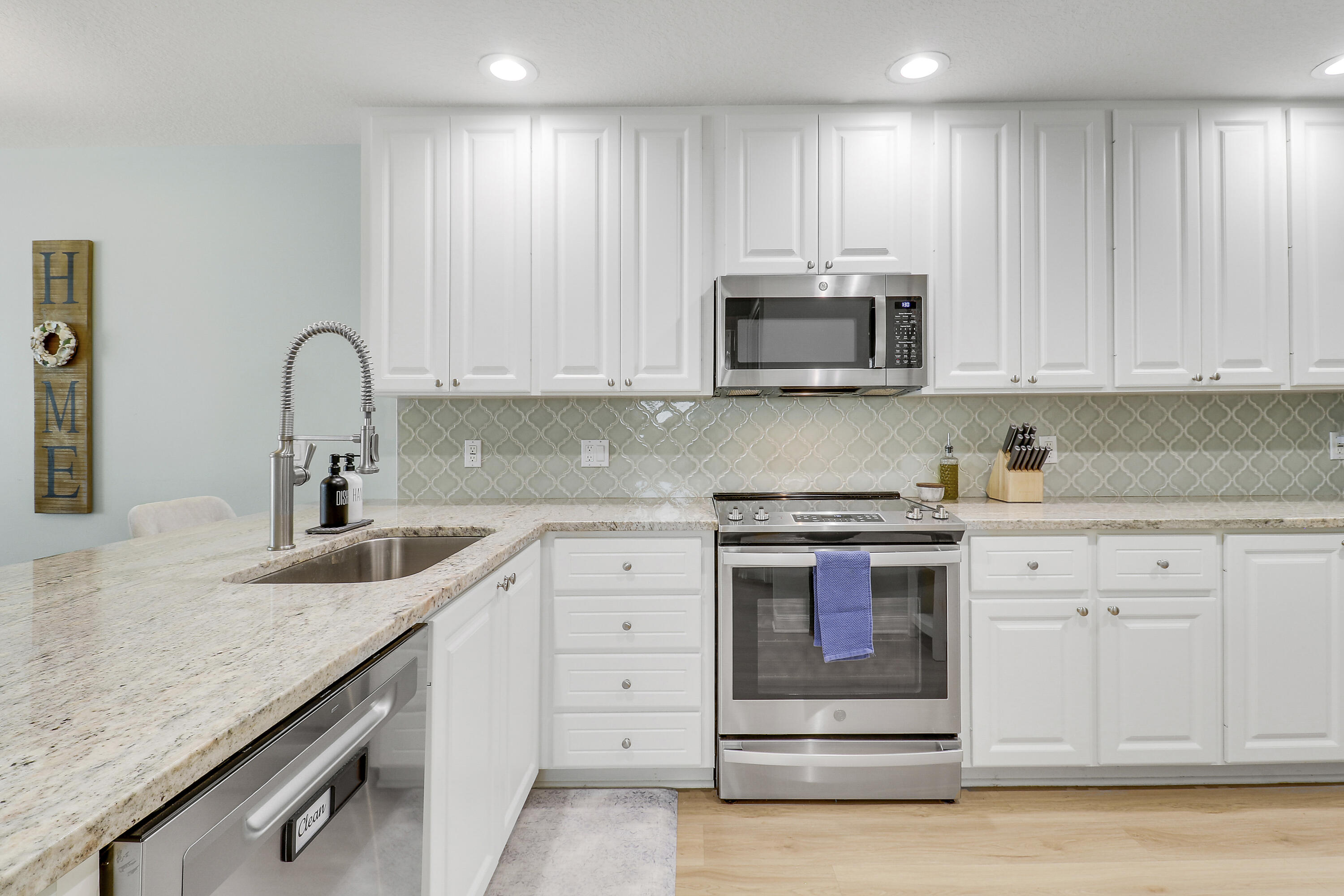151 Rivinia Drive Jupiter, FL 33458 - Photo 6 of 40 a kitchen with granite countertop white cabinets and stainless steel appliances