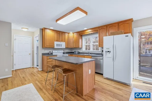 a kitchen with stainless steel appliances granite countertop a refrigerator and a stove top oven