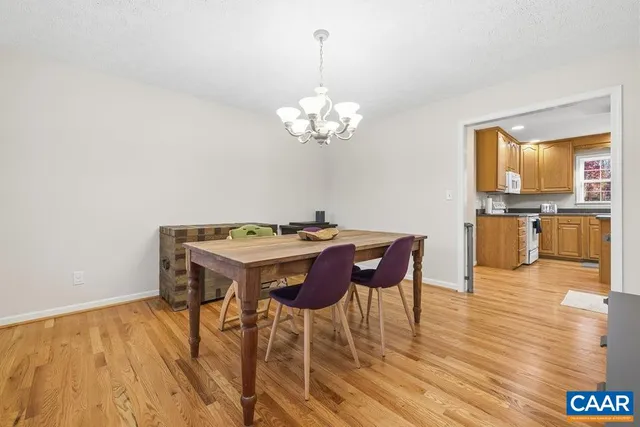a dining room with furniture a chandelier and wooden floor
