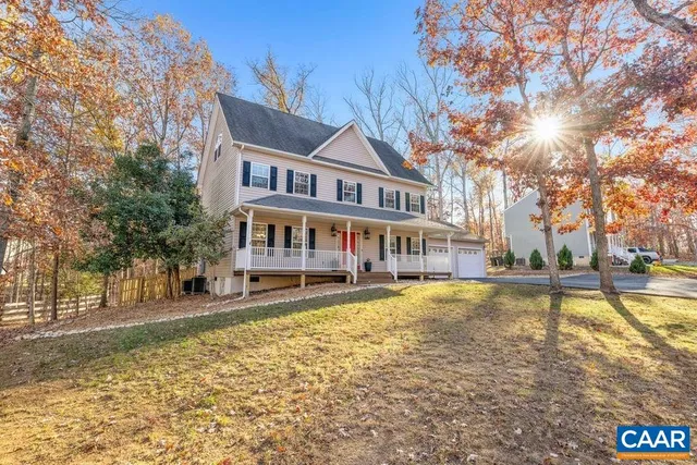 a view of a white house with a large pool with a yard and large trees