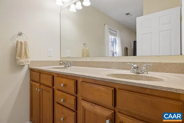 a bathroom with a double vanity sink and a mirror