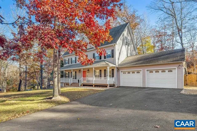 a front view of a house with a yard and palm trees