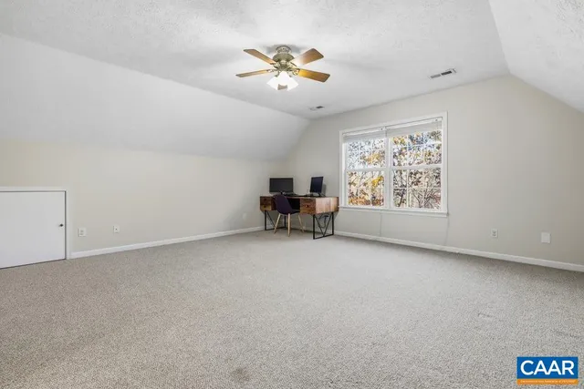 an empty room with windows and ceiling fan