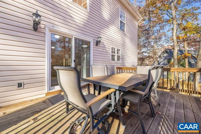 a roof deck with table and chairs and wooden floor