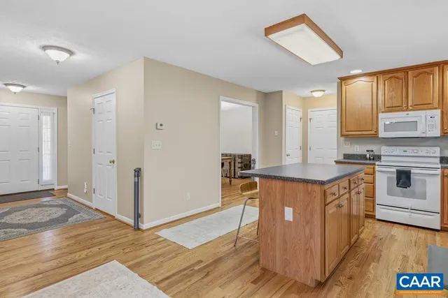 a kitchen with stainless steel appliances granite countertop a stove a sink dishwasher and a refrigerator with wooden floor