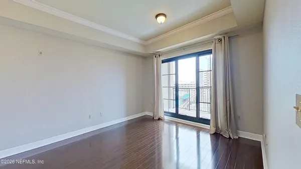 a view of a room with wooden floor and a chandelier