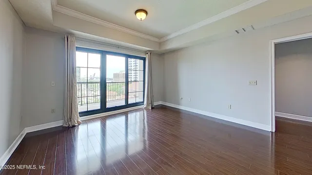 a view of a room with wooden floor and a chandelier