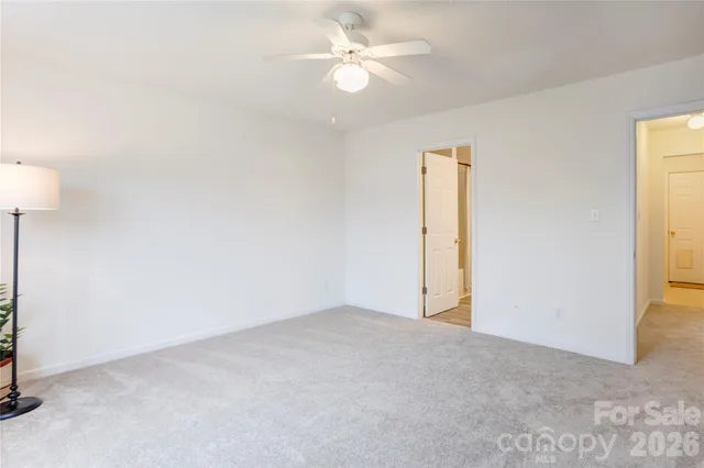 an empty room with a window and a ceiling fan