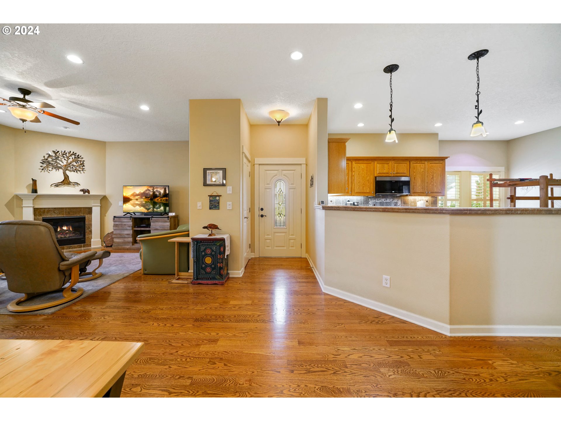 2155 Southeast Rhododendron Avenue Dallas, OR 97338 - Photo 9 of 40 a kitchen with stainless steel appliances granite countertop a refrigerator a stove top oven a sink dishwasher and a fireplace with wooden floor