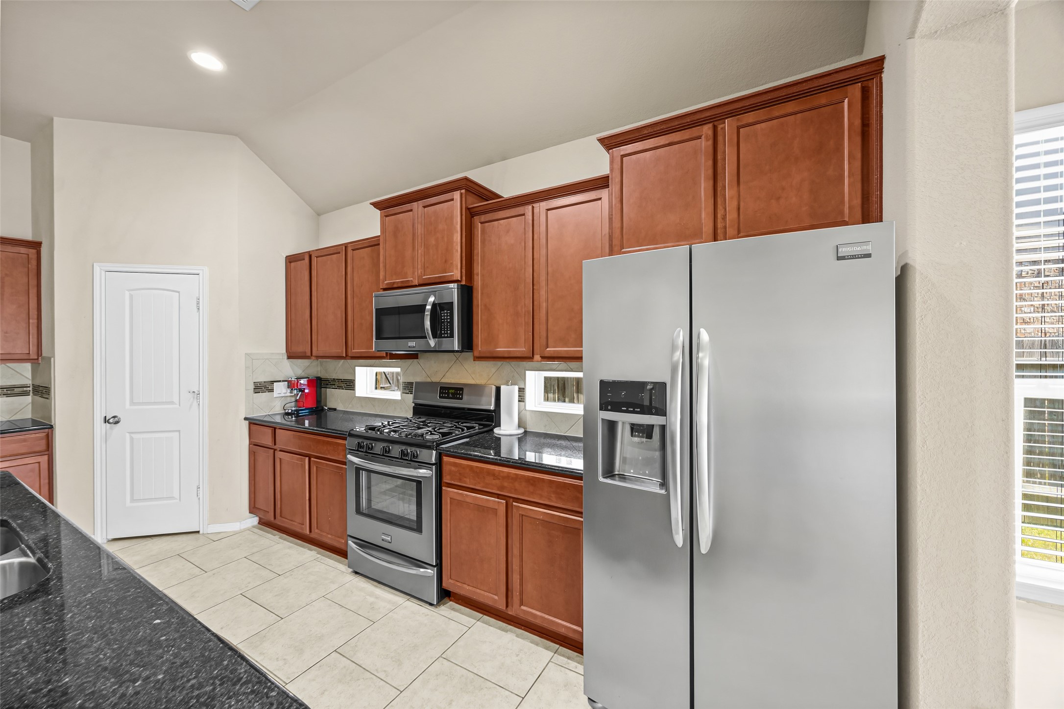 5615 Glenfield Spring Lane Spring, TX 77389 - Photo 11 of 28 a kitchen with stainless steel appliances granite countertop a refrigerator stove microwave and sink