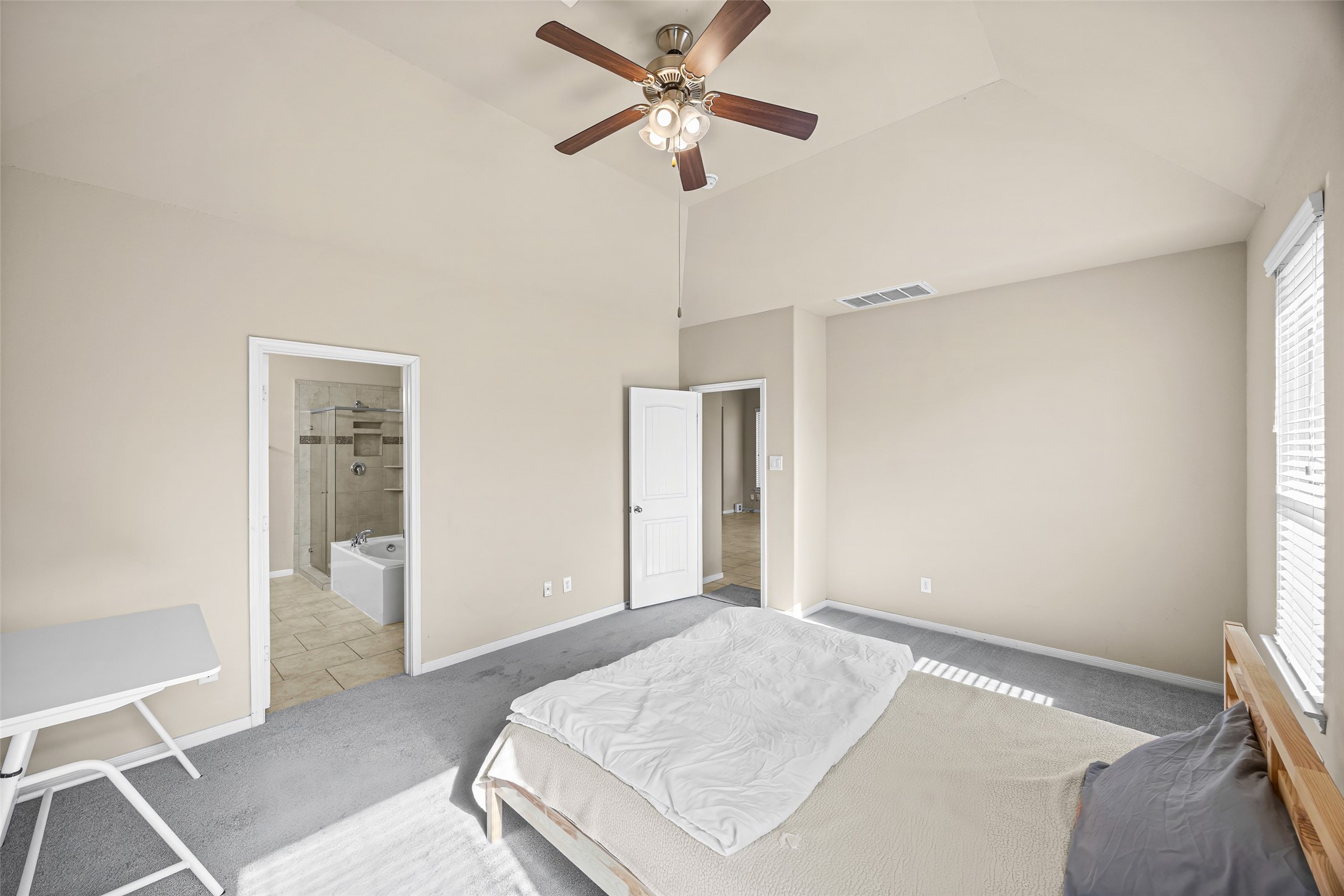 5615 Glenfield Spring Lane Spring, TX 77389 - Photo 22 of 28 a bedroom with a bed and a chandelier