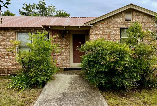 a view of a house with potted plants