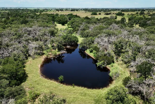 an aerial view of residential house with outdoor space and trees around
