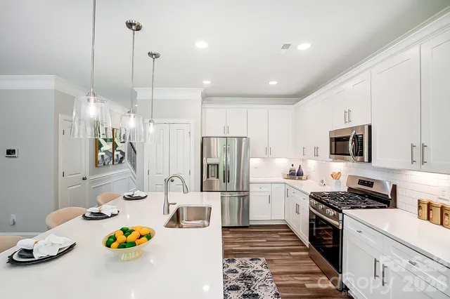 a kitchen with stainless steel appliances granite countertop a sink refrigerator and microwave