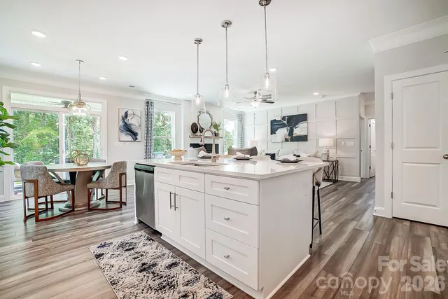 a kitchen with kitchen island granite countertop a sink cabinets and wooden floor