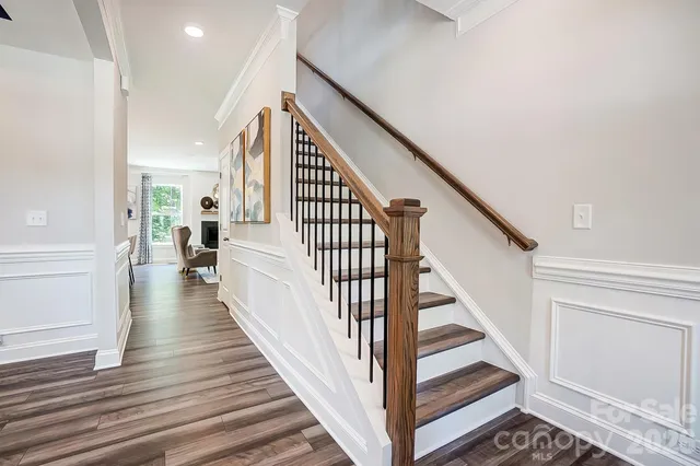 a view of a hallway with wooden floor and staircase