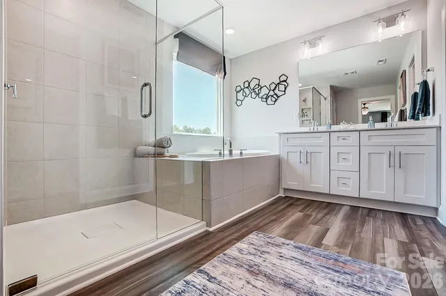 a spacious bathroom with a tub sink and mirror