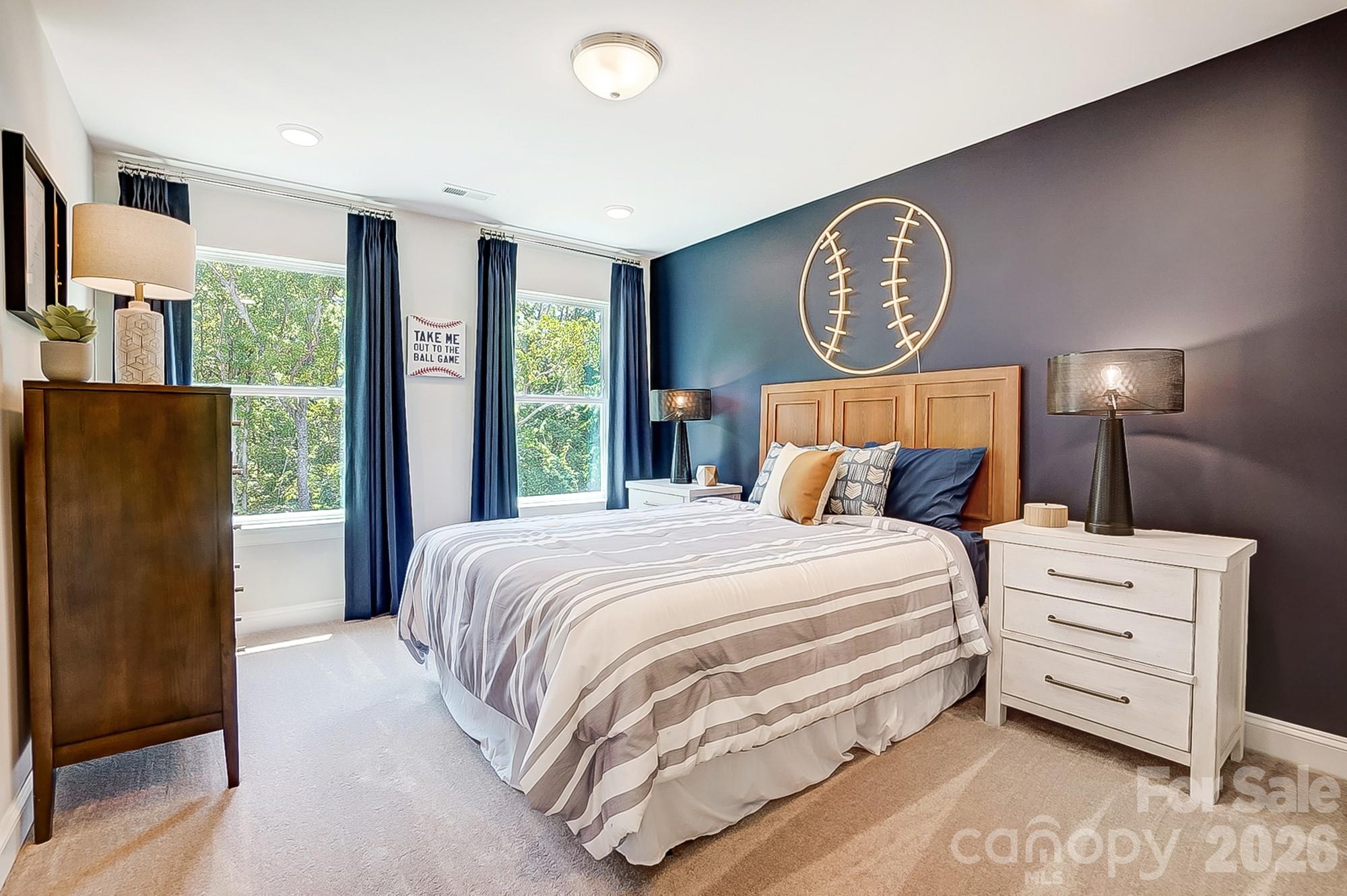 8615 Frank Grier Road Charlotte, NC 28215 - Photo 40 of 47 a bedroom with a bed a mirror on dresser and a large window