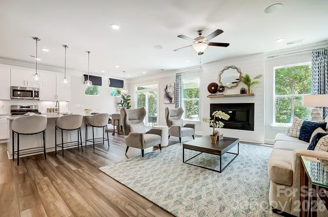 a living room with furniture a fireplace and a large window