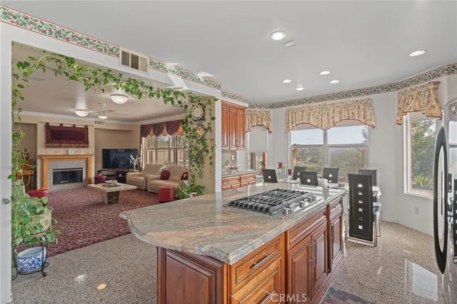 a kitchen island with stainless steel appliances granite countertop sink stove and refrigerator