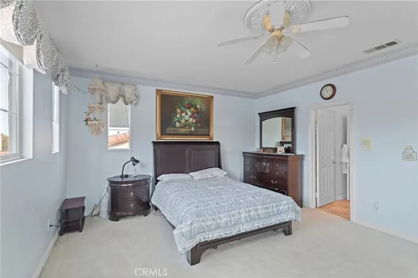 a bedroom with a large bed a chandelier and dresser