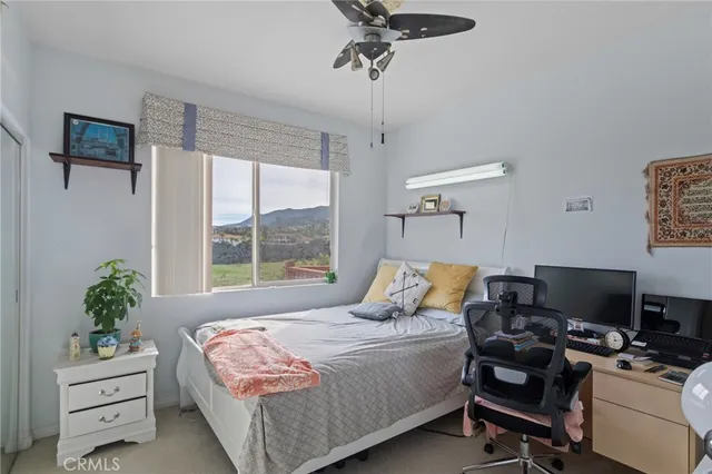 a bedroom with a bed and a computer on the desk