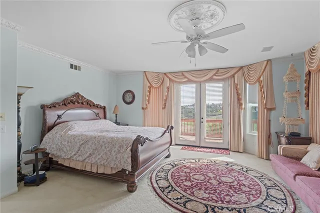 a bedroom with a large bed and a chandelier