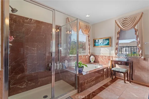 a bathroom with a granite countertop tub shower and mirror