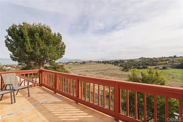 a balcony with wooden floor and lake view
