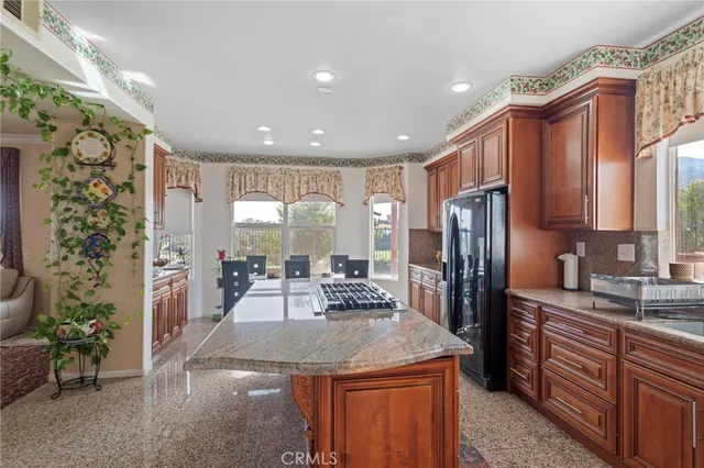 a kitchen with stainless steel appliances granite countertop a sink a stove a refrigerator and cabinets