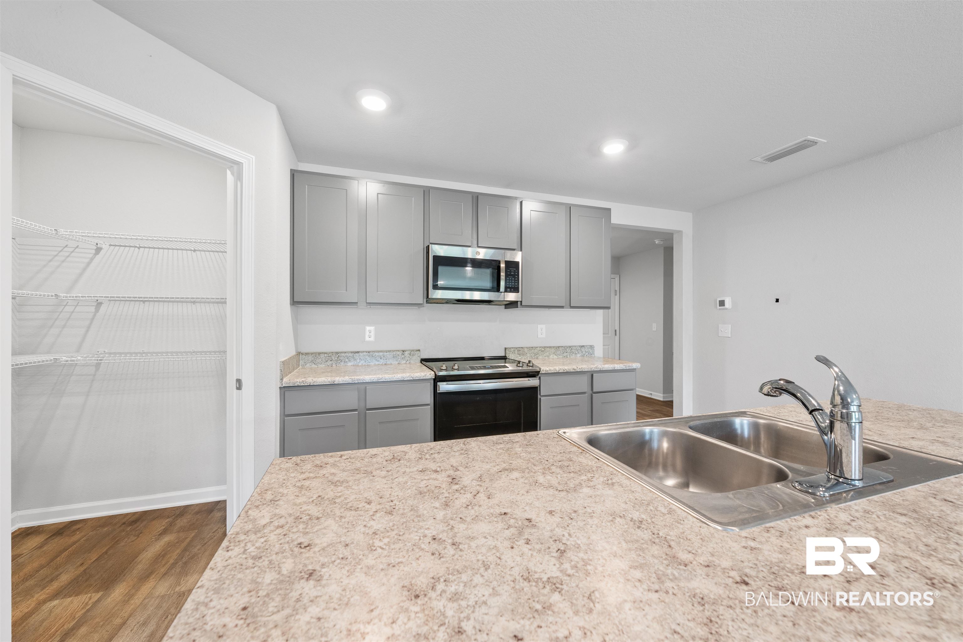 7457 Brompton Drive Foley, AL 36535 - Photo 5 of 24 Kitchen featuring gray cabinets, light countertops, stainless steel appliances, dark wood finished floors, and recessed lighting