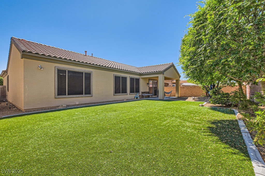 7513 Java Sparrow Street North Las Vegas, NV 89084 - Photo 26 of 36 Rear view of house featuring turf and fully fenced