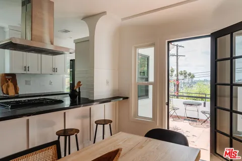 a kitchen with granite countertop a sink stove and cabinets